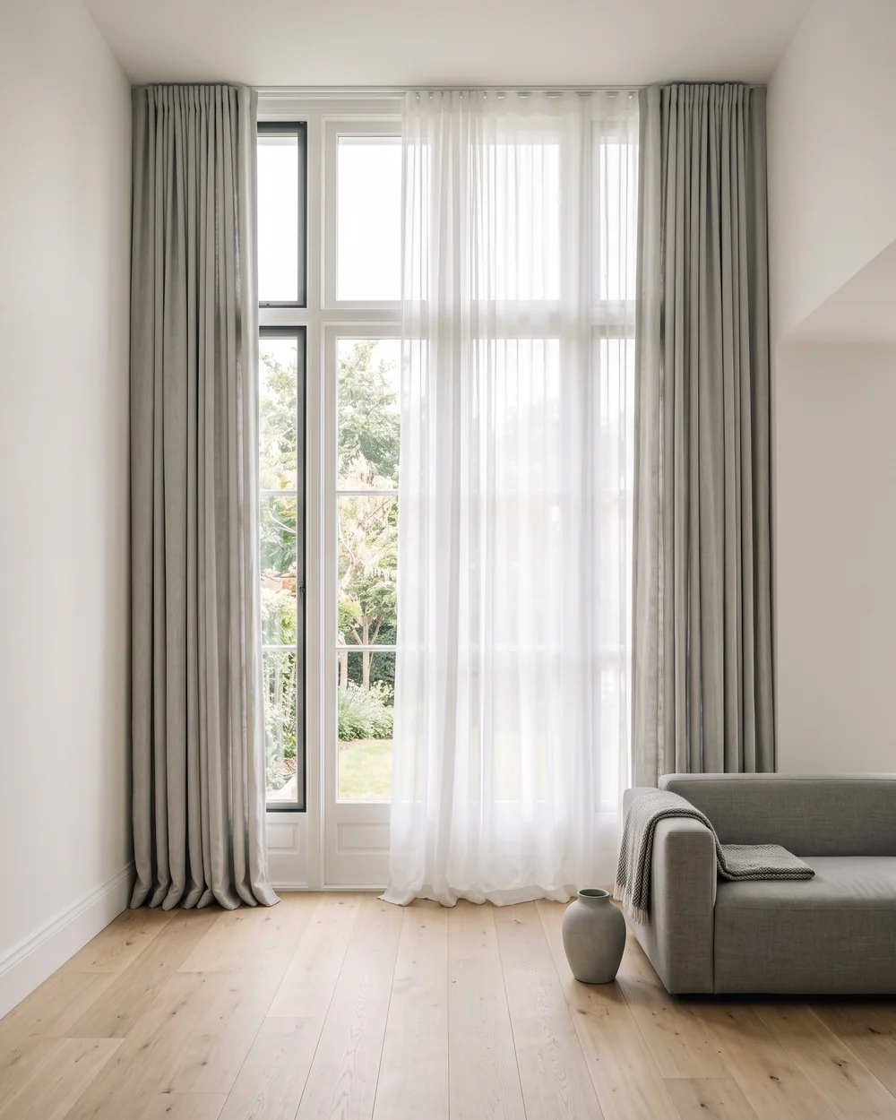 Bright residential living room with tall windows and curtains