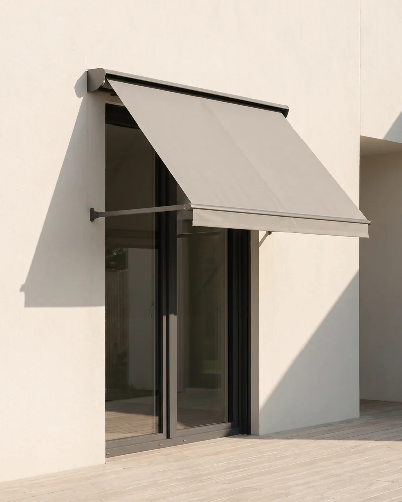 Retractable awning shading a window on a house exterior