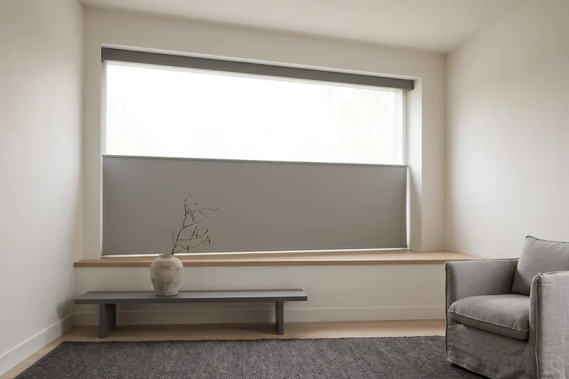 Blockout roller blind lowered halfway across a wide Brisbane living room window