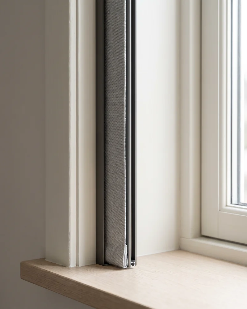 Side channel fitted alongside a blockout roller blind