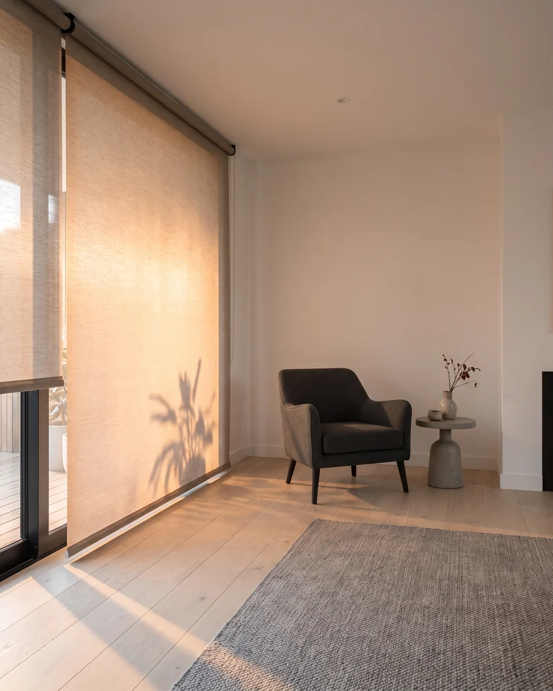 Roller blind lowered against low afternoon sun in a west-facing room