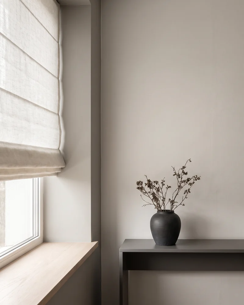 A Roman blind gathered into even horizontal fabric folds above a window