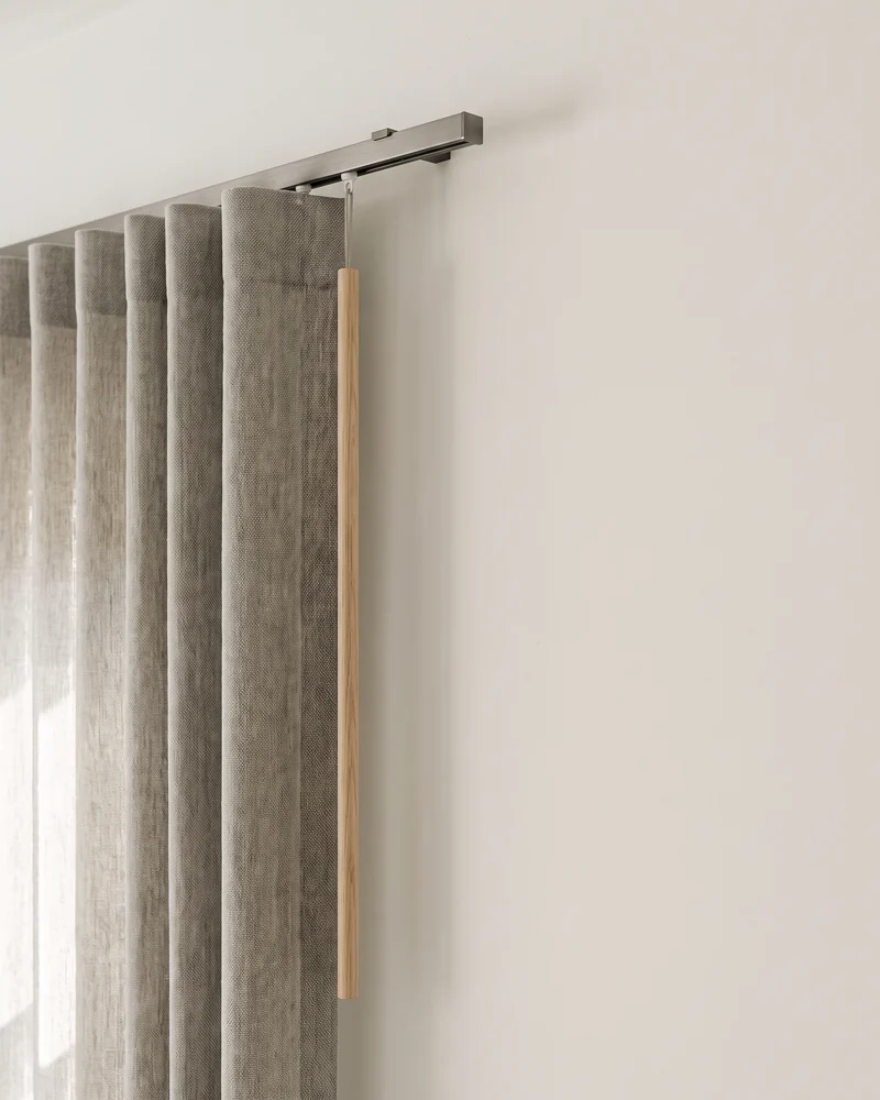 The leading edge of an S fold curtain operated by a baton wand, with no cord or chain at the side