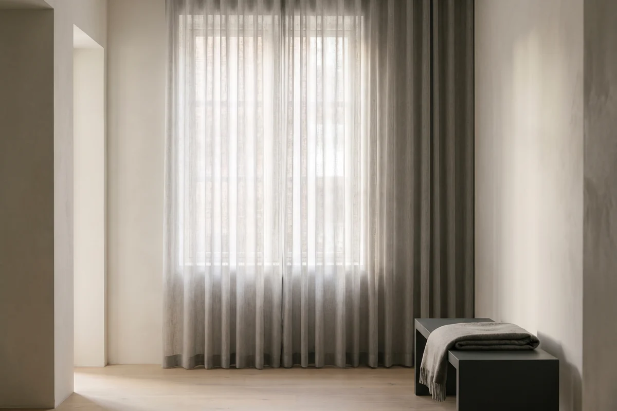 Sheer curtain fabric hanging in soft folds with daylight passing through