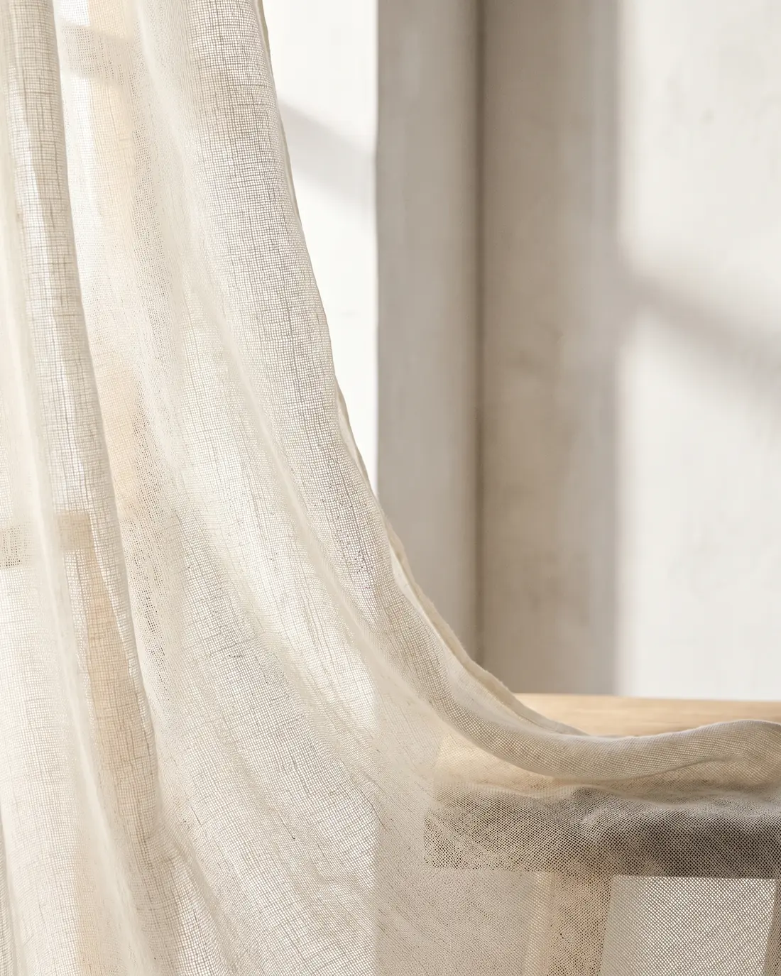 Close detail of sheer curtain fabric with daylight passing through it