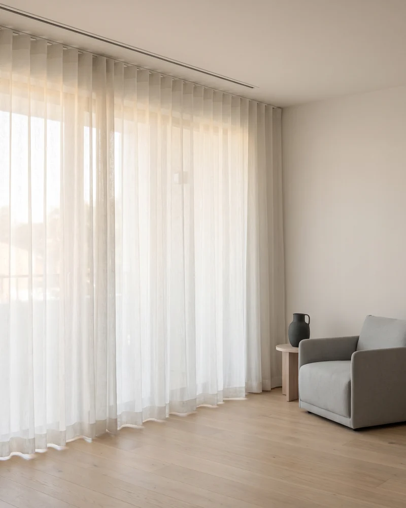 Sheer curtains across a floor-to-ceiling apartment window