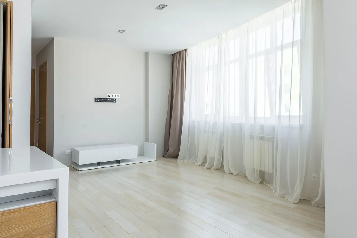 Sheer curtains hanging in a continuous S-shaped wave across a large window