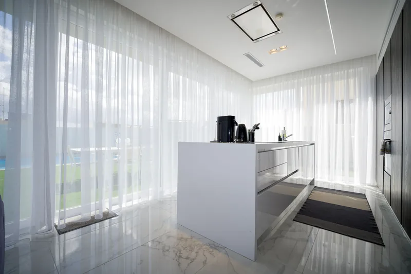Floor-to-ceiling sheer S fold curtains falling in an even wave beside a wide living room window