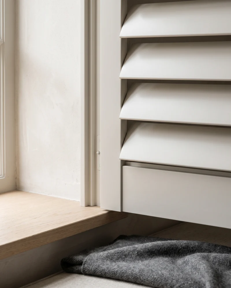 Close view of shutter louvre blades meeting the panel stile, with no cord or chain
