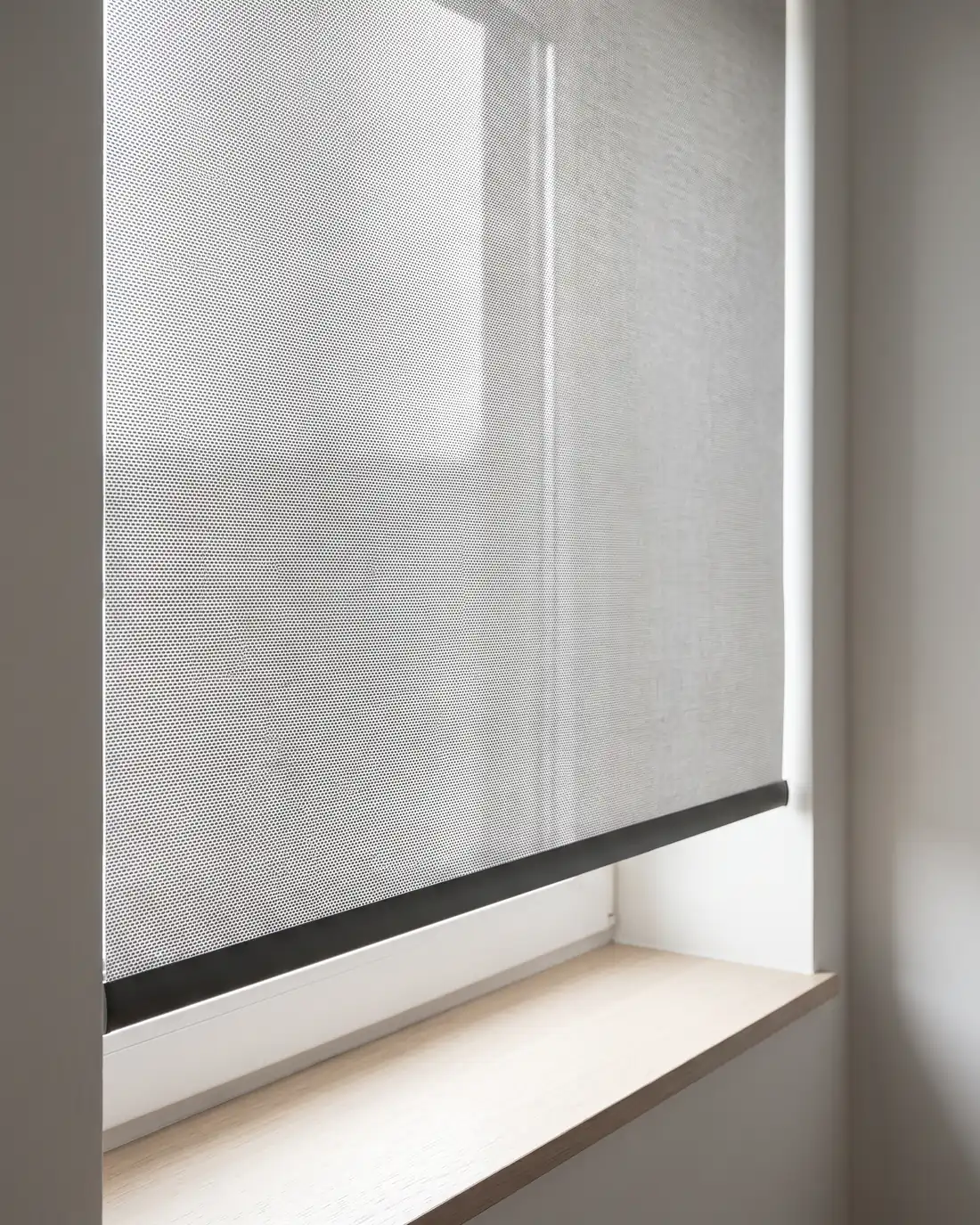 Close-up of a metallised sunscreen blind fabric with daylight behind it
