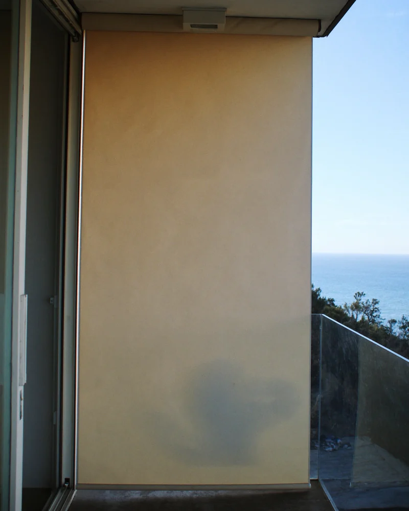 A straight-drop outdoor blind on a balcony