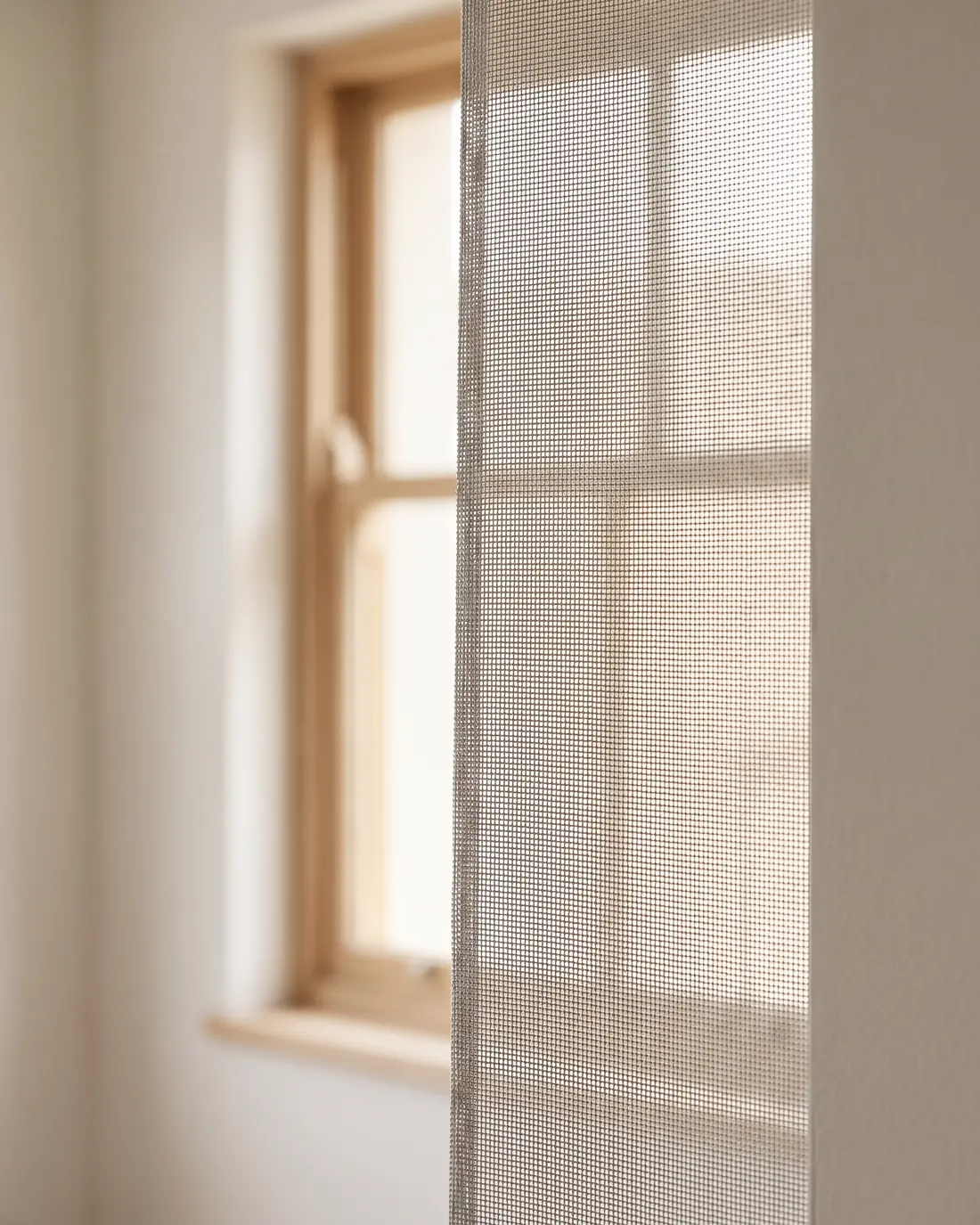 Close detail of sunscreen roller blind fabric with daylight behind it