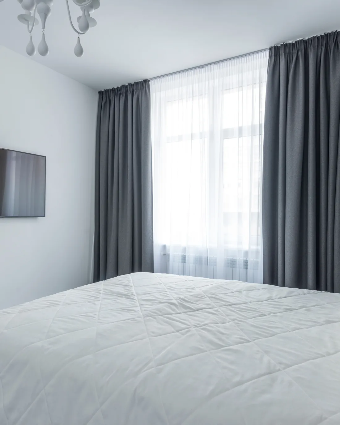 Full-length curtains framing a tall bedroom window