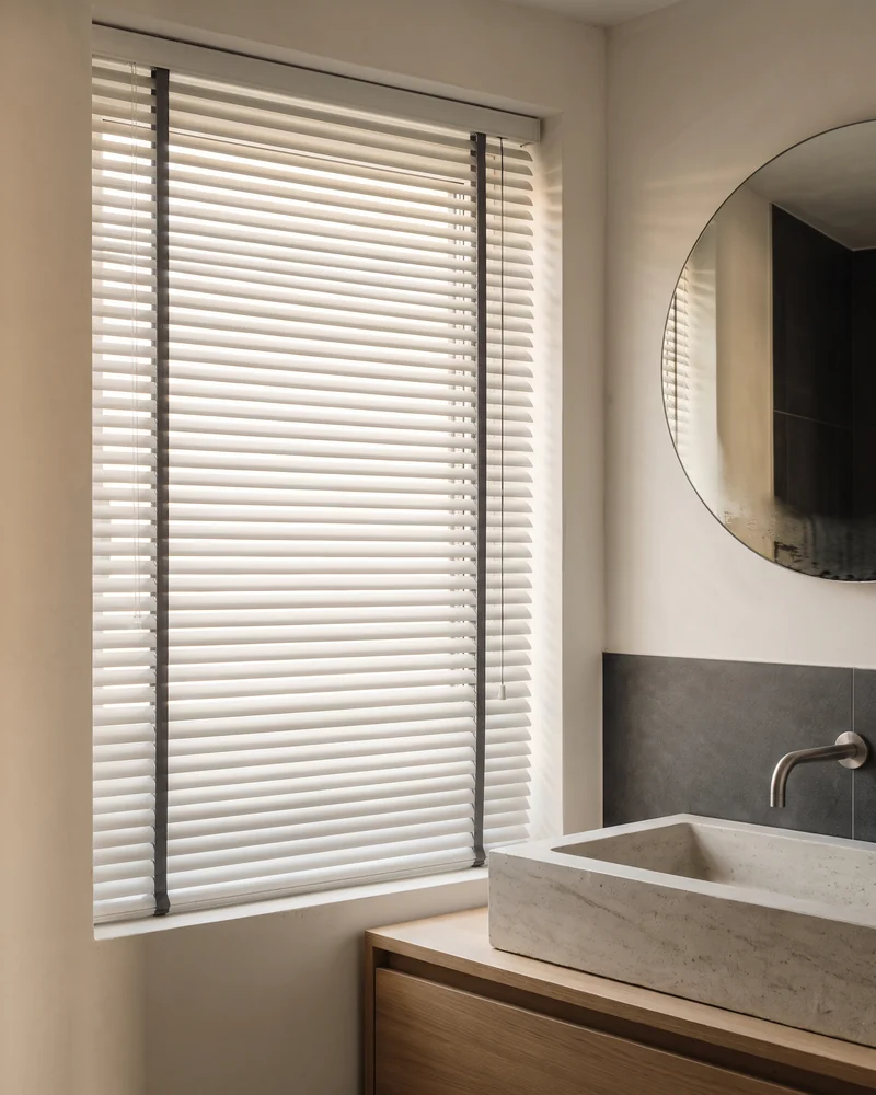 Aluminium venetian blind at a bathroom window above a vanity