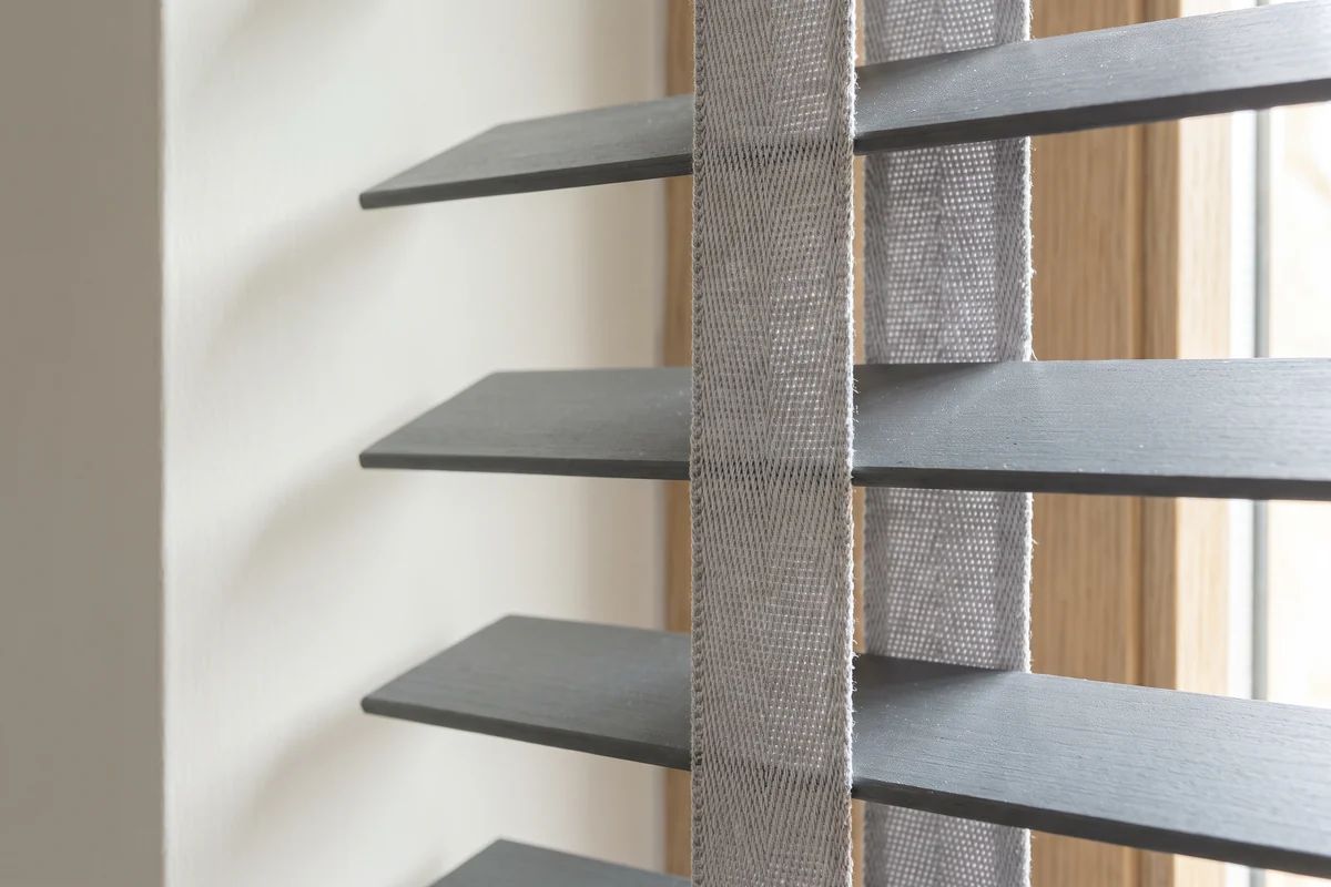 The woven ladder tape running down a row of venetian slats