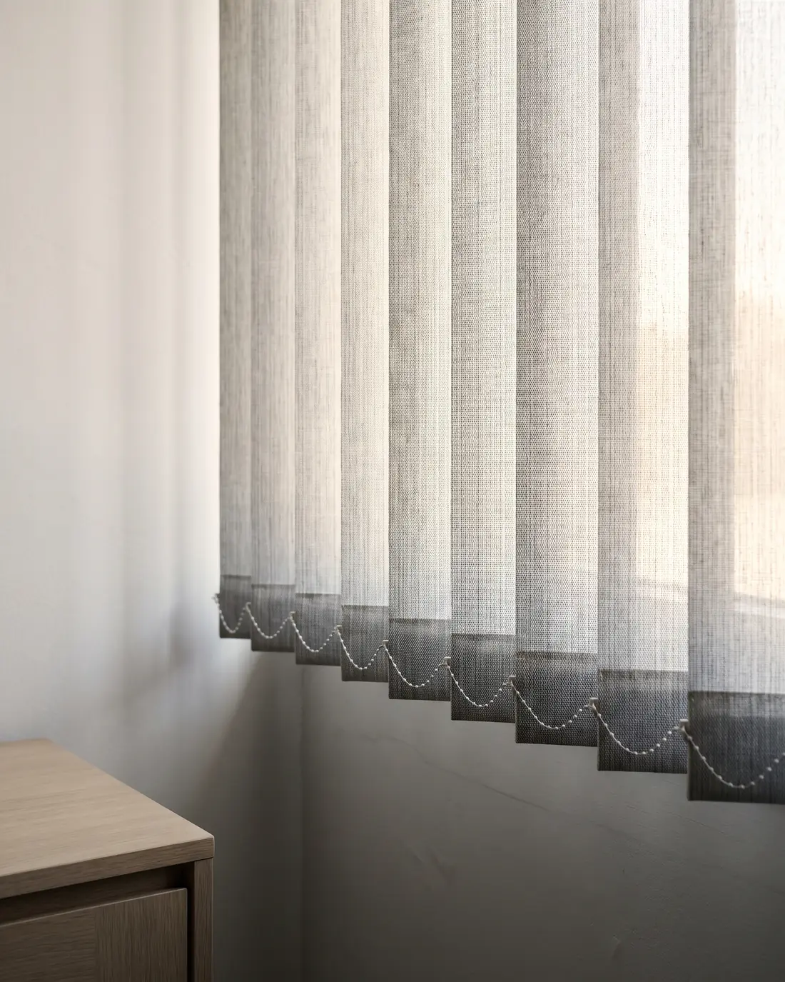 Close detail of vertical blind louvres angled against daylight