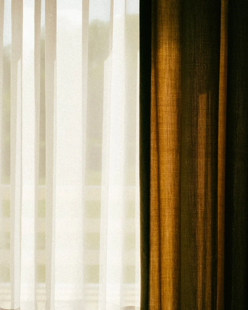 A sheer and a heavier drape hanging together at a window