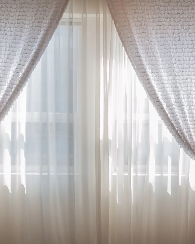 Sheer curtains filtering daylight at a window