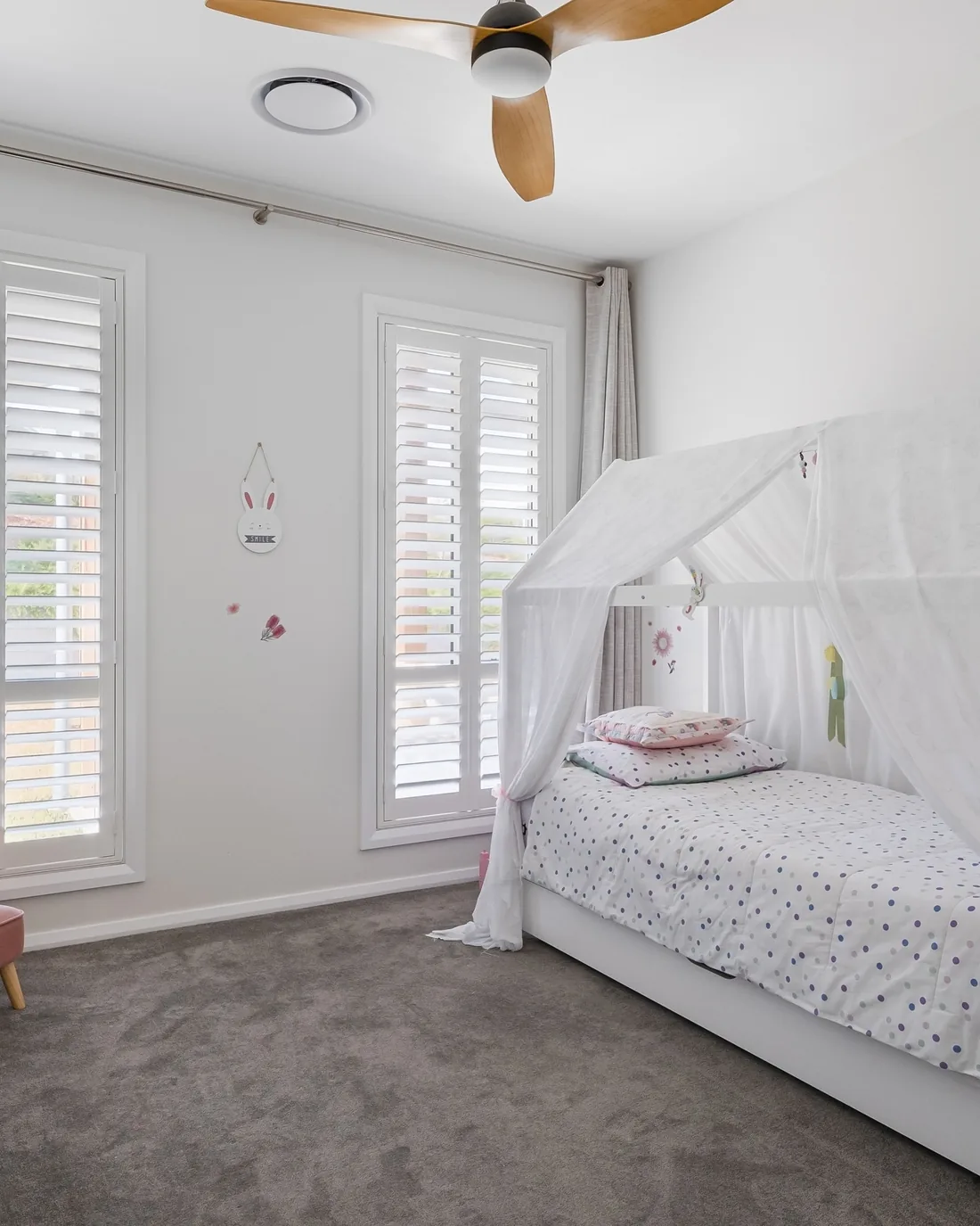 Polymer shutters with the louvres tilted open in a bedroom