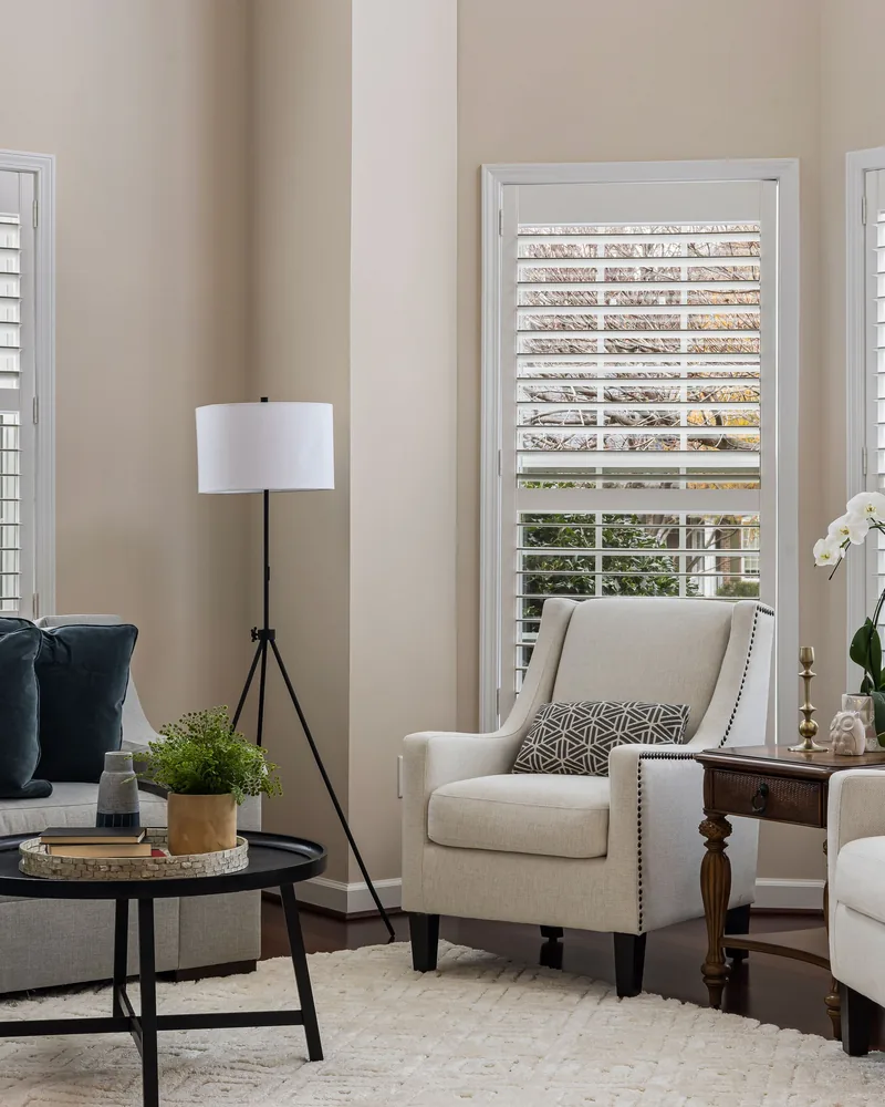 Living room windows fitted with white shutters