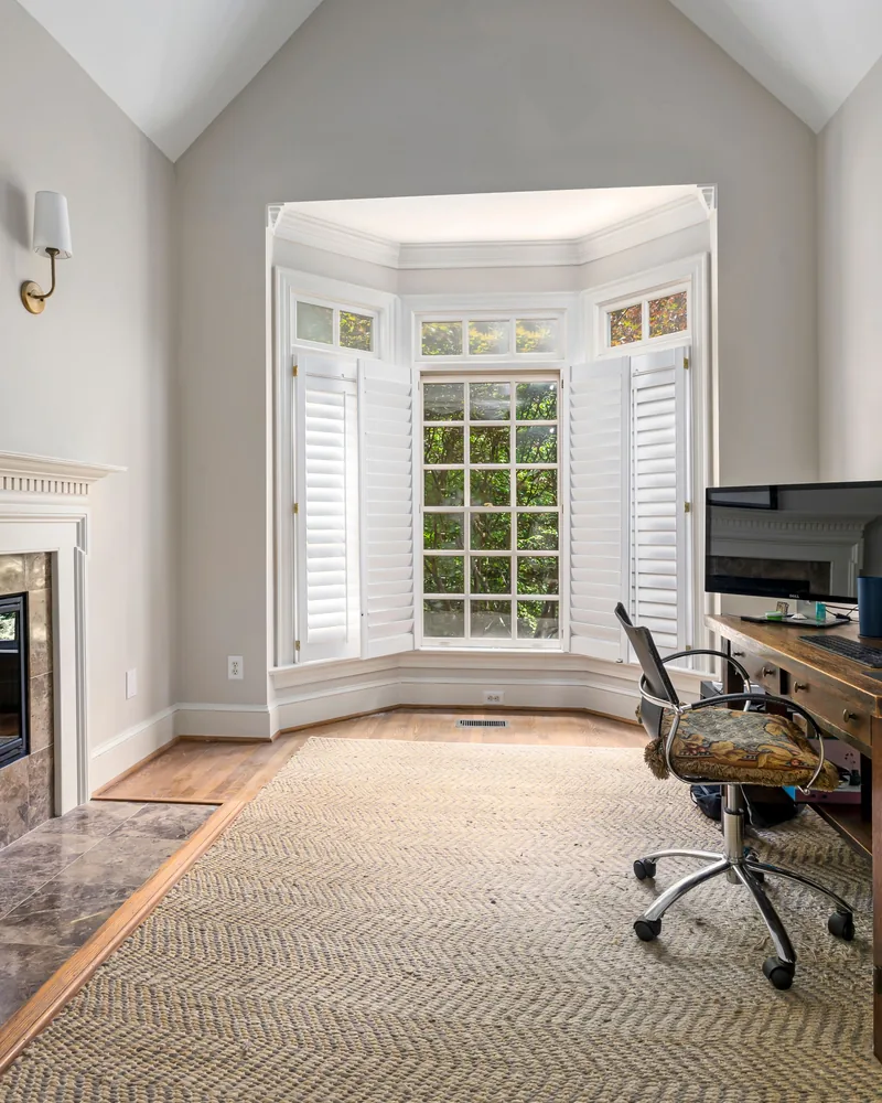 Hinged shutter panels folded open across a bay window